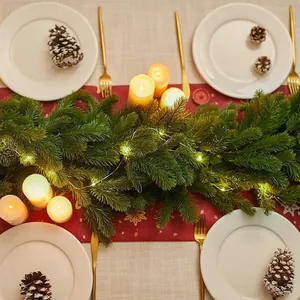 Artificial PE Christmas garland with warm LED lights displayed on a festive dining table