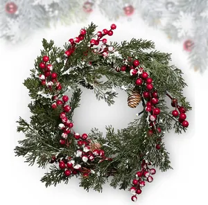 Detail of Christmas wreath with red berries, natural pine cones and artificial snow coating