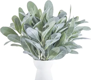 Gros plan de tiges d'oreilles d'agneau artificielles dans un vase blanc minimaliste