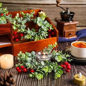Kerstkrans kaarsenhouder met rode bessen en eucalyptus voor een feestelijke tafeldecor