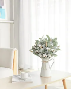 Détail de tiges d'oreille d'agneau et de coton dans un vase minimaliste en céramique blanche
