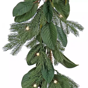 Üppige Weihnachtsgirlande mit Magnolienblättern, Kiefernnadeln und warmen LED-Lichtern auf Weiß