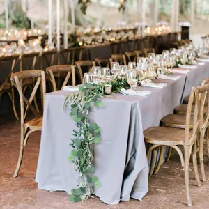Close-up of elegant light grey rectangular tablecloth with draping for wedding decor