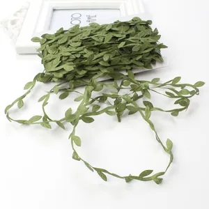 Detail view of olive green artificial eucalyptus leaf ribbon wrapped on a white card