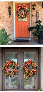 Close-up of autumn harvest wreath with orange pumpkins, peonies and berries on a door