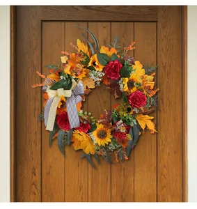 Close-up of fall wreath with sunflowers and maple leaves on a wooden door