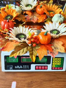 Gros plan d'une couronne d'automne avec feuilles d'érable et citrouilles sur une balance