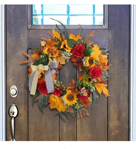 Close-up of autumn harvest wreath with sunflowers and maple leaves on a dark wooden door