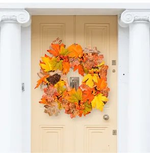 Detail of autumn wreath with maple leaves, berries, and burlap bow on a wooden door