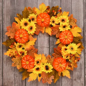 Detalle de corona otoñal con mini calabazas, girasoles y hojas de arce de color naranja