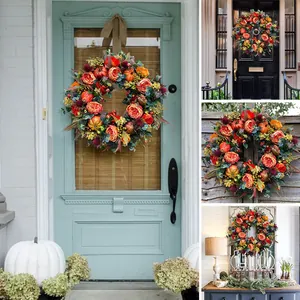Herbstkranz mit Kürbis und orangefarbenen Rosen für Erntedankfest Türdekoration