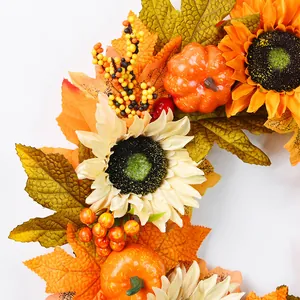 Détail de couronne d'automne avec feuilles d'érable, tournesols, citrouilles et baies