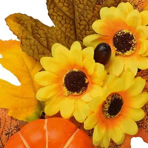 Corona de otoño con girasoles amarillos, calabaza, hojas de membrillo y piñas naturales