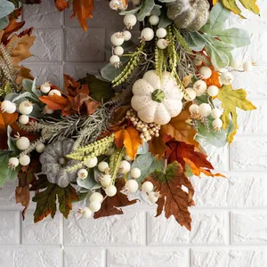 Détail d'une couronne d'automne avec feuilles d'érable, citrouilles et baies
