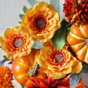 Fall wreath with orange daisies, artificial pumpkins and green eucalyptus leaves for front door