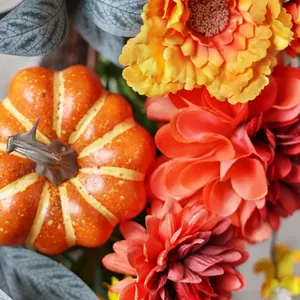 Autumn wreath with colorful faux flowers, pumpkin and eucalyptus leaves for front door