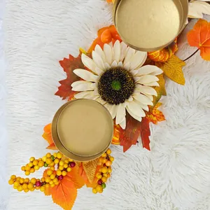 Détail de couvercles de bougeoirs dorés avec feuilles d'érable et tournesol