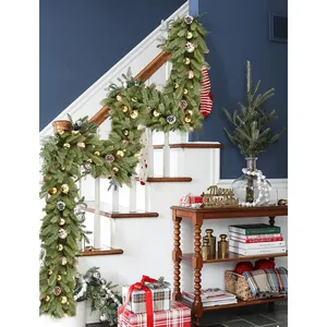 Lush green artificial pine Christmas garland with gold baubles and natural pine cones