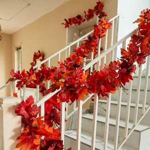 Artificial autumn maple leaf garland wrapped on a white staircase for festive home decor