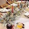 Christmas table runner with flocked pine branches, gold ornaments, and red candles
