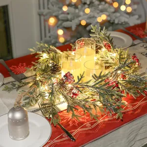 Detail von Weihnachtskranz mit roten Beeren, Zapfen und LED-Kerzen für Tischdeko