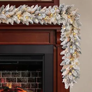 Detail of 9ft flocked Christmas garland with warm LED lights on a wooden mantel
