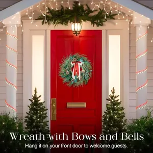 Detail of 60cm Christmas wreath with red bow and bells on a festive red front door