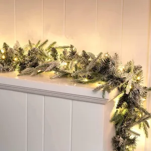 Detailed view of 6.3ft flocked Christmas garland with warm white LED lights on a mantel