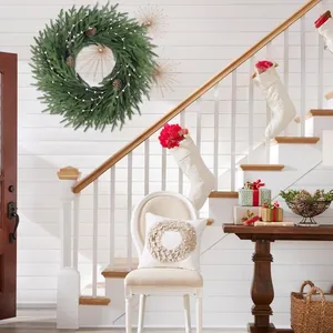 Couronne de Noël artificielle de 26 pouces avec pommes de pin sur un mur blanc