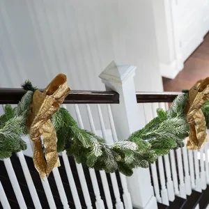 Détail d'une guirlande de Noël de 180cm avec flocage de neige et nœuds dorés sur escalier