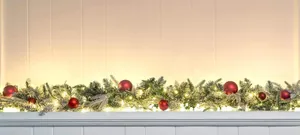 Detail of 6.3ft flocked Christmas garland with red ornaments and warm white LED lights