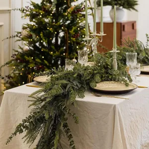 Close-up of 6ft artificial Norfolk pine and eucalyptus garland on a festive dinner table