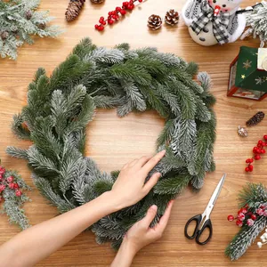 Détail de guirlande de Noël 180cm avec aiguilles enneigées et baies rouges sur bois