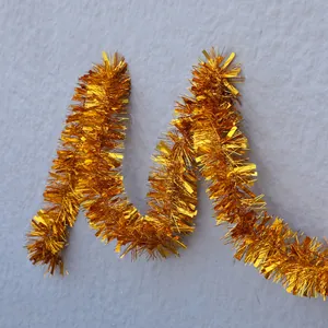 Close-up of shiny gold tinsel garland with metallic fringe for party and wedding decoration