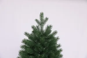 Close-up of artificial PE Christmas tree top with lush dark green needles and layered branches