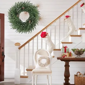 Couronne de Noël artificielle 26 pouces avec pommes de pin et baies sur mur blanc