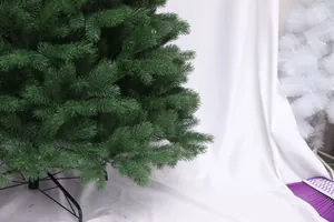 Detail view of artificial green Christmas tree with dense needles and black metal stand
