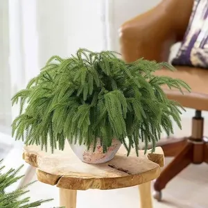 Artificial Norfolk pine greenery in a stone pot on a wood stand for home decor