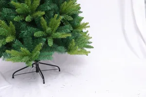 Detailed view of dark green artificial Christmas tree branches and black metal base stand