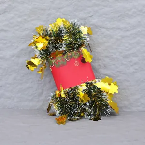 Détail d'une guirlande verte à paillettes dorées enroulée sur une bobine festive
