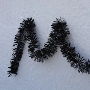 Shiny black tinsel garland hanging on a wall for Halloween and Christmas party decorations
