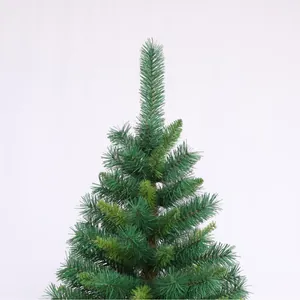 Close-up of artificial PVC Christmas tree top with lush green needles on white background