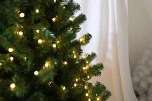 Gros plan d'un sapin de Noël artificiel avec lumières LED blanc chaud et aiguilles en PE