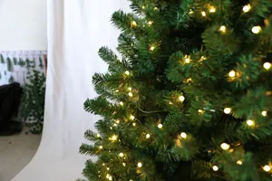 Détail de branches de sapin de Noël en PE avec guirlandes lumineuses LED blanc chaud