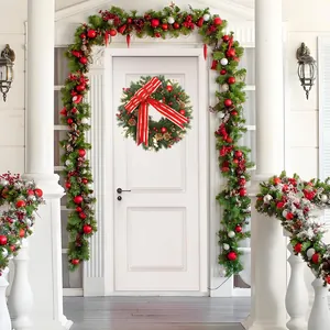 Detailed view of Christmas wreath and garland set with red bows and gold pinecones