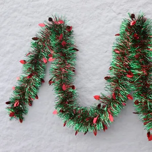 Christmas tinsel garland with green fringe and red holly leaf accents for party decor