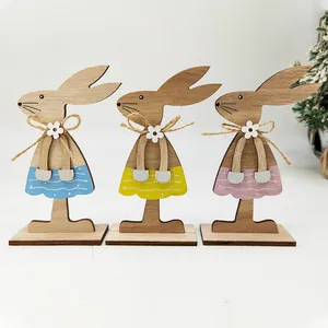 Three wooden Easter bunny figurines with colorful painted skirts and hemp rope bow accents