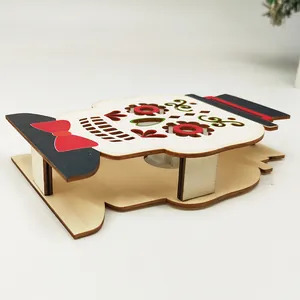 Halloween wooden skull ornament with black top hat and red bow on white background