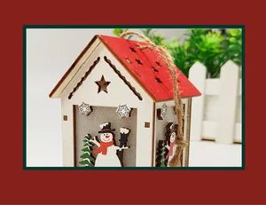 Close-up of wooden Christmas house ornament with red star roof and snowman patterns