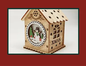 Close-up of wooden Christmas house with carved XMAS text and festive snowman detail